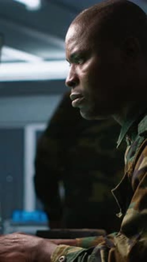 Man in Camouflage Working at Computer at Night