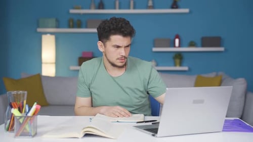 Young Adult Excitedly Working on Laptop at Desk