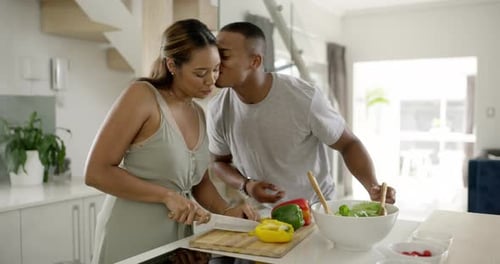 4k video footage of a young married couple cooking together in the kitchen at home