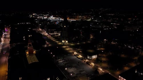 Illuminated street of small american town at night. Houses and homes in downtown. Aerial top down ri