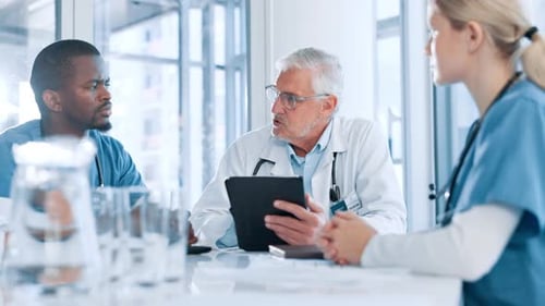 Medical Team Discussing Patient Data on Tablet