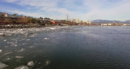 Sobrevolando un río congelado con puentes y un cielo brumoso. Hermosos y tranquilos fragmentos de i