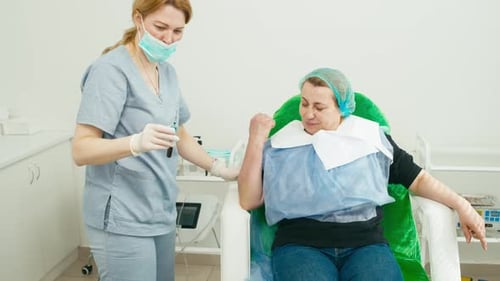 Nurse Taking Blood Sample from Smiling Patient