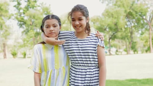 Two Smiling Girls Standing Together in Green Park