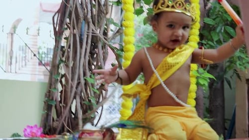 adorable infant dressed as hindu god krishna cute facial expression with flute at janmashtami
