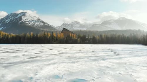 Vue aérienne de la surface gelée du lac de Strbske Pleso avec l'hôtel et les sommets des Hautes Tatras en hiver