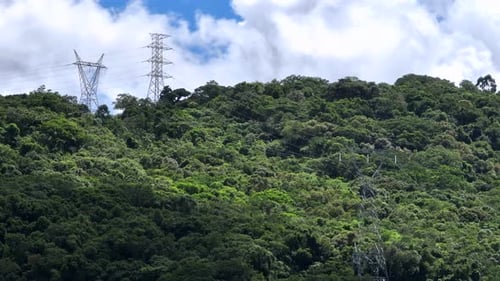 Lush Green Mountainside with Electricity Pylon Towers