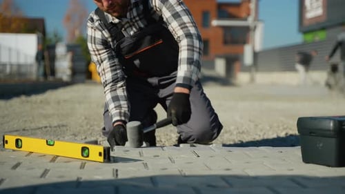 Construction Worker Installing Pavement with Tools