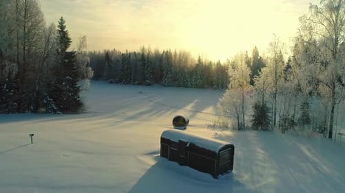 Aerial View of Snowy Landscape With Wooden Saunas