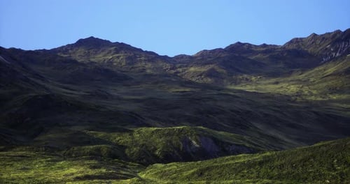 Serene Green Mountains Under Clear Blue Sky in a Remote Location