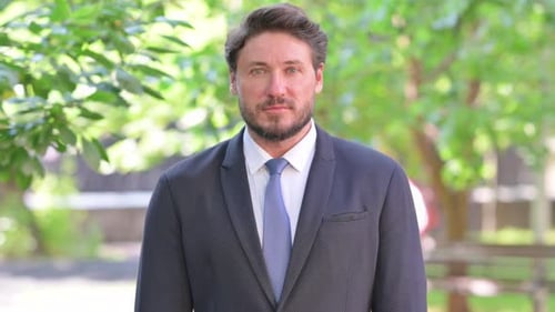 Man in Suit Standing Outside on Sunny Day