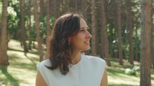 A Woman Enjoying the Tranquility and Beauty of Nature in a Picturesque Pine Forest