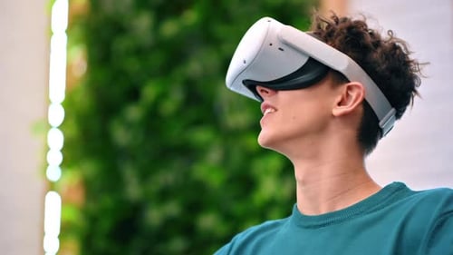 A young excited caucasian man exploring virtual reality using VR glasses in an office