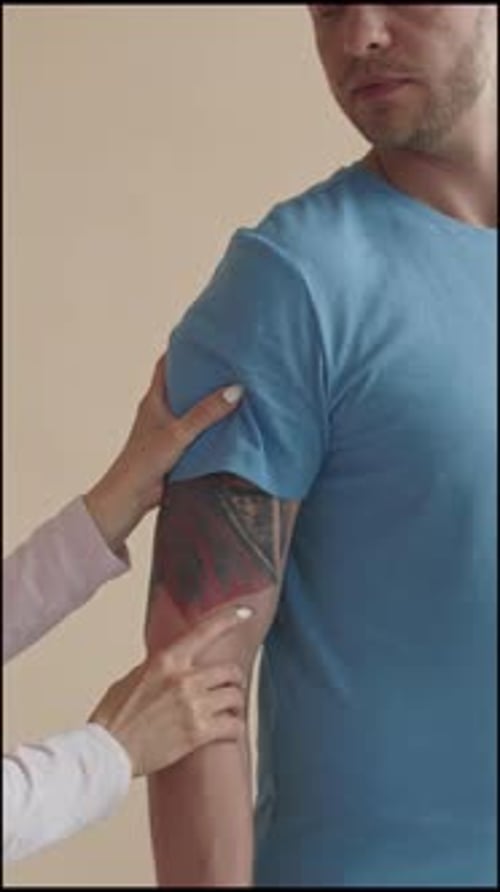 Man Talking to Female Physiotherapy Doctor during Checkup