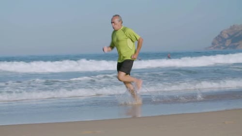 Confident Man Running Barefoot Fast on Sandy Beach