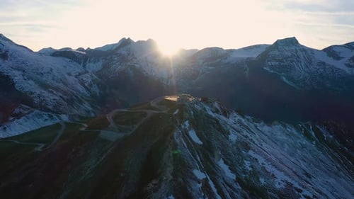 evening aerial view of snowed Alps summits with beams of setting sun, Hohe Tauern national park,
