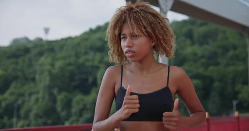 Young African American Woman Runner Jogging on City Bridge Outdoors