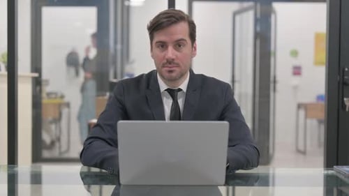 Man in Suit Working at Laptop in Office