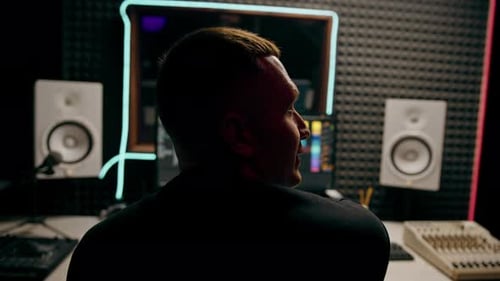 recording studio sound engineer producer mixes songs on screen colorful audio tracks professional