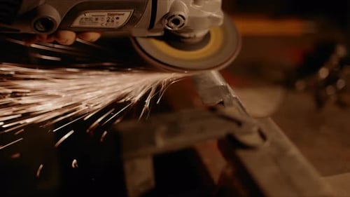 making new knife sanding metal with electric grinder (close up)