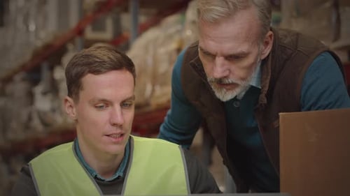 Warehouse Managers Working on Laptop Together