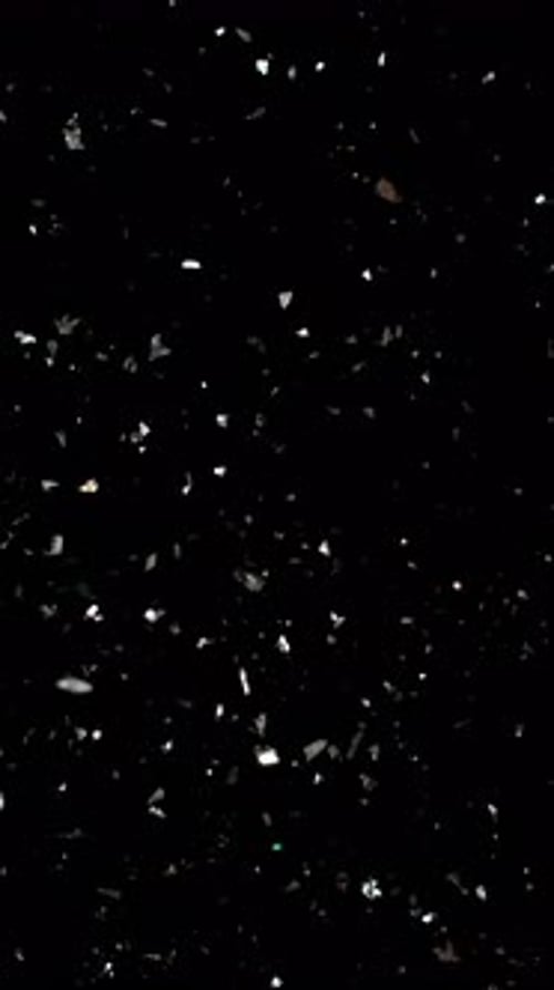 Silver Confetti Falling on Black Background