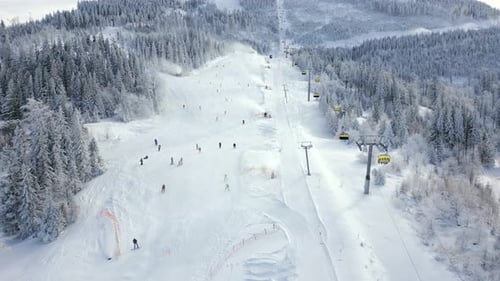 Aerial View of Snowy Ski Slope with Chairlifts and People Skiing