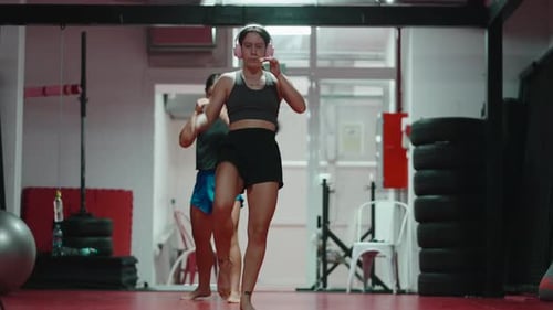 Female Muay Thai Fighters Shadow Boxing in a Gym