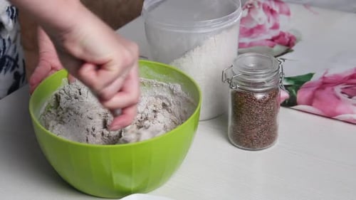 Preparing Dough in a Green Bowl with Seeds