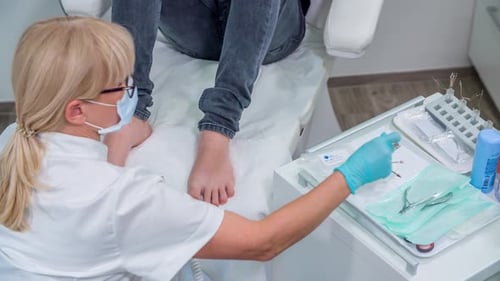 Foot Doctor Works on Patient's Foot in Office