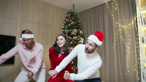Three Cheerful Friends Dancing at Christmas Party