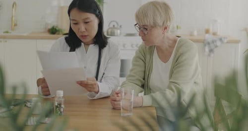 Doctor Explains Medical Information to Senior Woman at Home