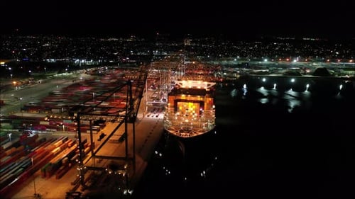Porto noturno aéreo sobre navio descarregando e carregando contêineres em Southampton. Envio e logística.