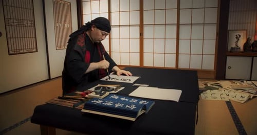 Japanischer männlicher Kalligraphie-Künstler, der künstlerische Symbole in Kanji-Zeichen zeichnet