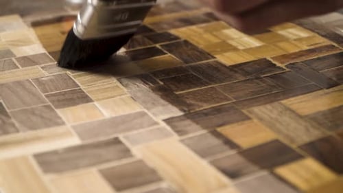 Close shot of a paint brush putting wood oil on a wood