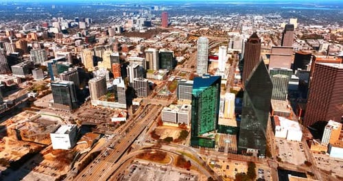 Sunny panorama of Dallas downtown with wide-lane highway in centre. Top view on the city at daytime.