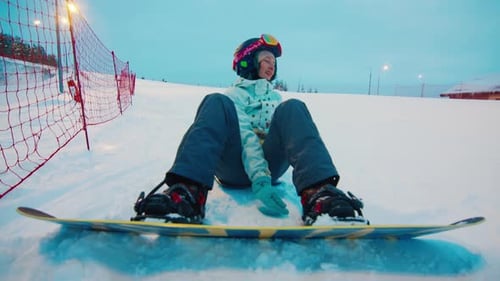 First time on snowboard. Woman learns snowboarding on the slope
