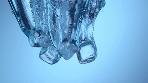 Ice Cubes Falling Into Clear Water with Bubbles