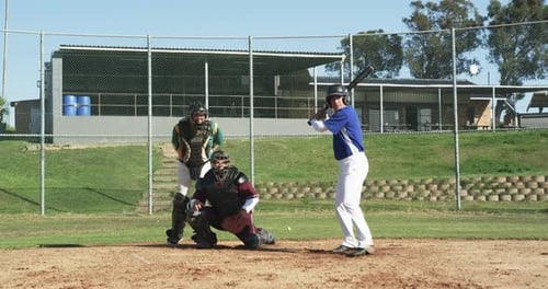 Baseball Batter Swinging at Ball on Baseball Field