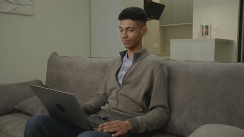 Man on Video Call Using Laptop African American Man Talking to Computer Working at Home Office
