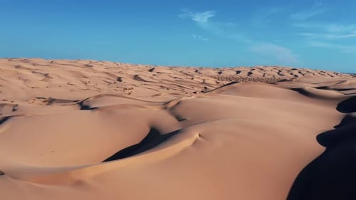 Kilometerlange Sanddünen vor blauem Himmel, Drohnenschuss