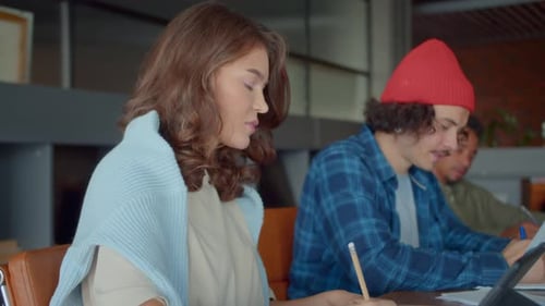 Une femme collabore avec un jeune homme pour préparer une offre commerciale