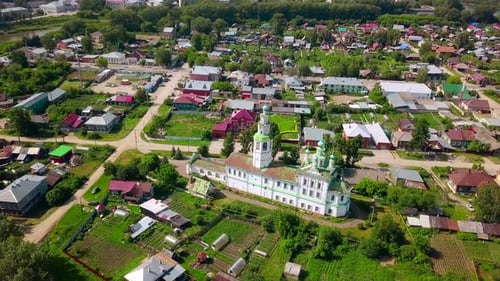 Old colorful church in town by river on sunny day