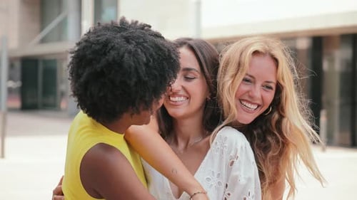 Three Friends Laughing and Embracing in City