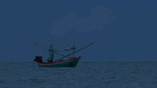 Fishing Boats in Thailand wait in the middle of the ocean for dark to come so they can turn on their