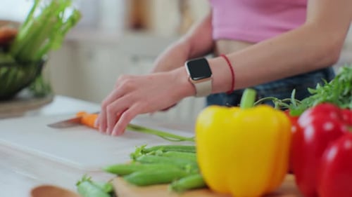 Close Up of Hands of Young Woman Cutting Vegetables in the Kitchen Preparing Fresh Vegetable Salad