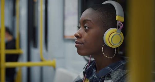 Black Woman With Headphones Travelling on a Train