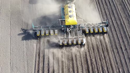 Tractor with yellow seeder working on the field in Ukraine OA Lexa