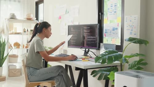 Chica asiática programadora de desarrollo de TI que escribe en el teclado programando en casa.