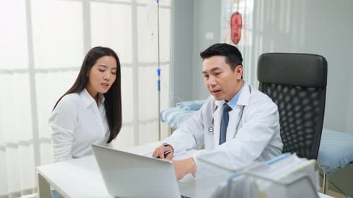 Doctor Talking to Patient About Laptop in Office